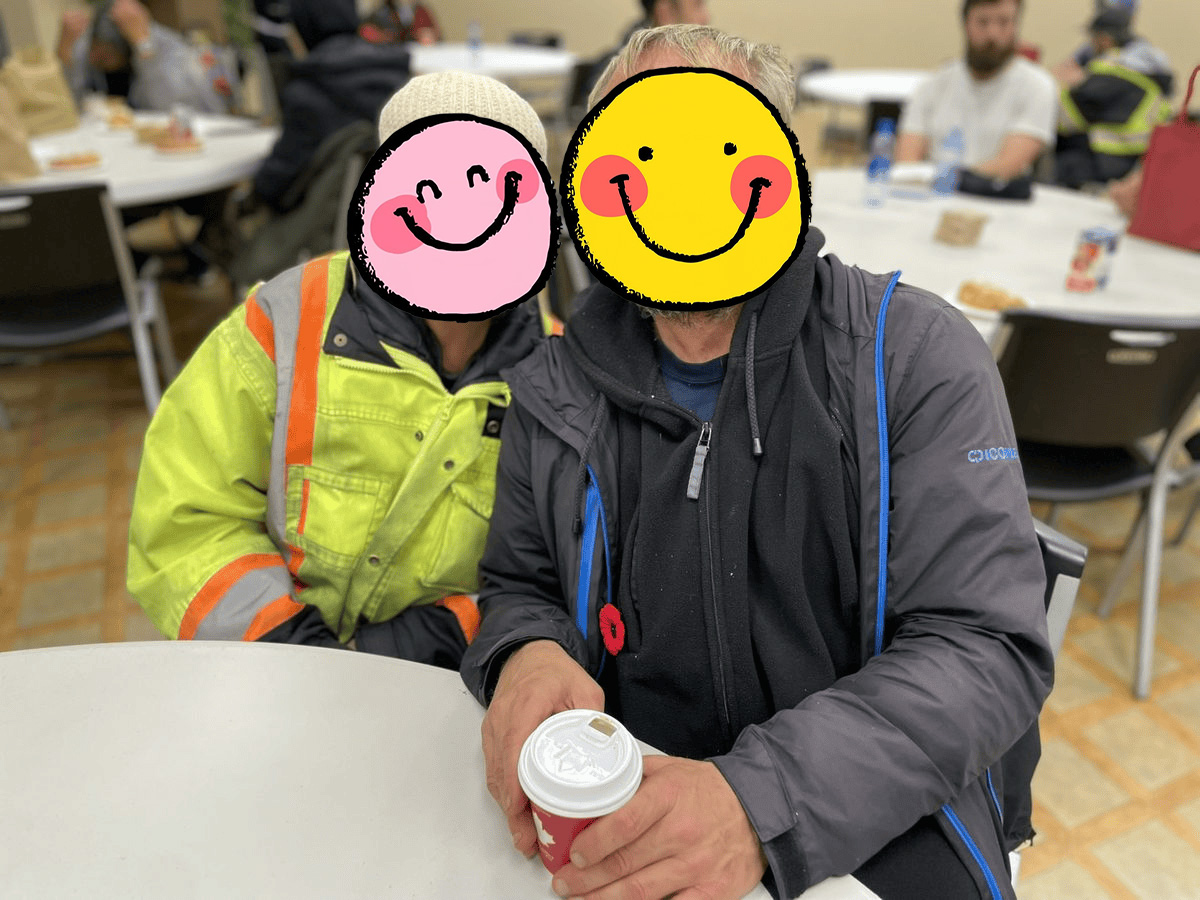 Two community members sharing coffee and a moment at the fair