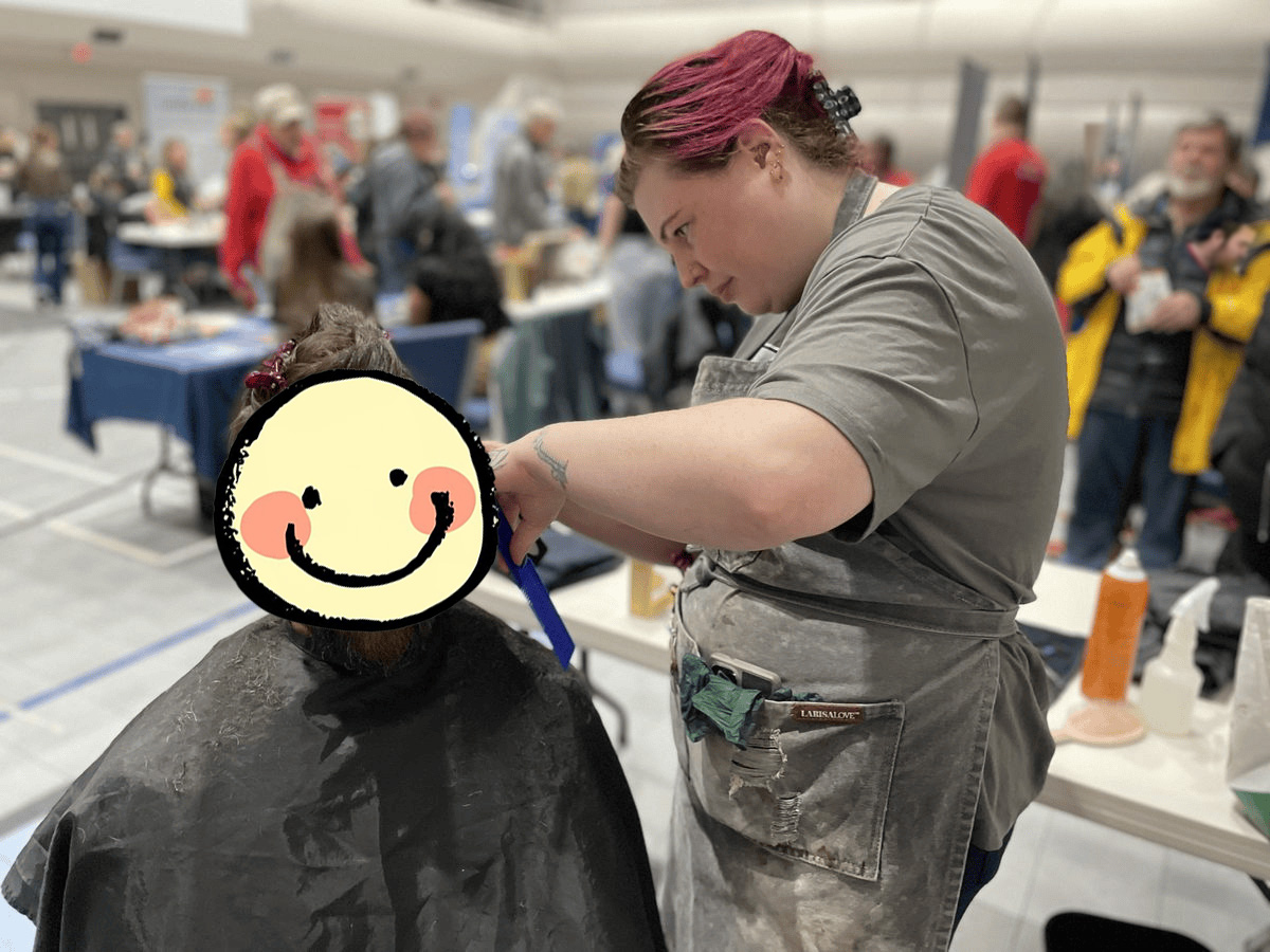 Community member receiving a haircut during the fair