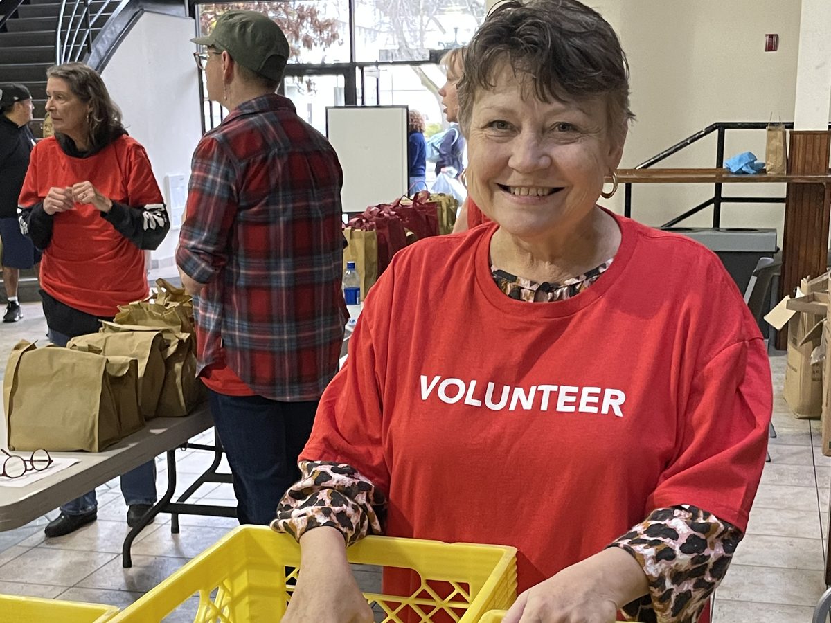 Volunteer packing care pack supplies into crates
